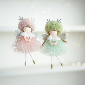 Detail of plush Christmas angel dolls with glitter wings and tulle skirts in soft pastel colors