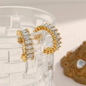 Détail de boucles d'oreilles C plaquées or 18 carats avec zircon rectangulaire sur verre