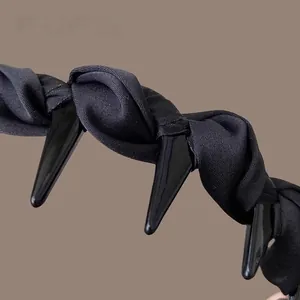 Detail of black gothic headband with satin fabric texture and edgy punk rivet spikes
