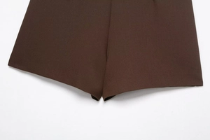 Detailed close-up of dark brown twill fabric texture and fine stitching on trousers