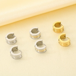Flat lay of minimalist C-shape huggie earrings in gold and silver matte finishes