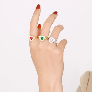 Detailed view of heart-shaped crystal rings in red, green and white on a model's hand