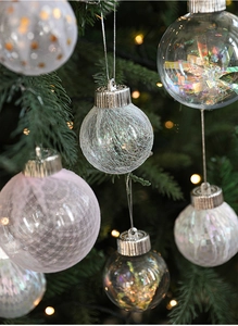 Close-up of pink and transparent Christmas balls with lace detail hanging on a tree