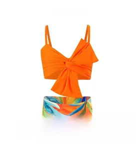 Detail of orange bikini top with large bow and tropical print high waist swim bottoms