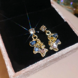 Detailed macro of 18k gold plated pony earrings with sparkling colorful rhinestones
