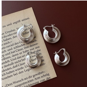 Macro detail of matte S925 sterling silver hoop earrings with clear hallmark engraving