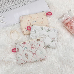 Flat lay of three quilted cotton cosmetic bags with cute bear and rabbit patterns