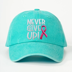 Detailed close-up of NEVER GIVE UP embroidery on a turquoise washed cotton baseball cap