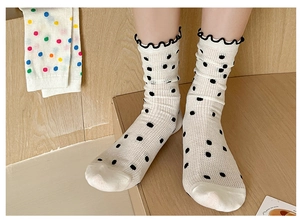 Detail of cream mesh ankle socks with black polka dots and ruffled trim decoration