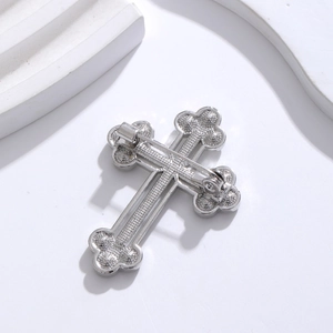 Elegant silver cross brooch pin with metallic luster shown from a professional top view