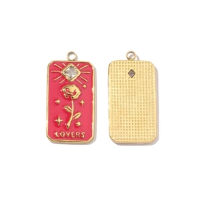 Detailed macro view of gold-plated stainless steel rectangular charms with red enamel