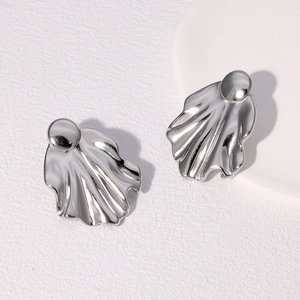 Detailed view of silver irregular wavy stud earrings with polished metallic texture
