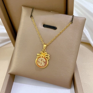 Detailed view of a gold lucky bag pendant with pink gem and zircons in a gift box