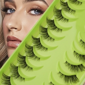 10 pairs of dense natural false eyelashes in a bright green tray held by a model