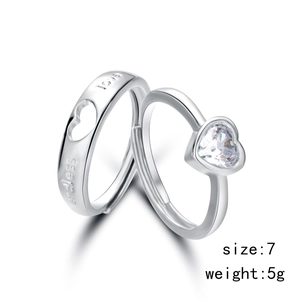 Detailed macro view of silver-tone couple rings with heart hollow design and 5g weight