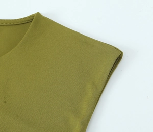 Dettaglio dello scollo e della spalla dell'abito in maglia verde oliva con intagli
