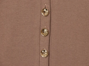 Macro view of knit fabric texture with three embossed golden metal buttons on camel outfit