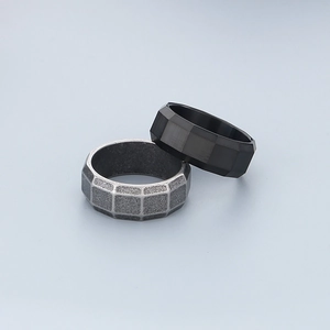 Detail of 8mm brushed grey textured ring and black faceted stainless steel band for men