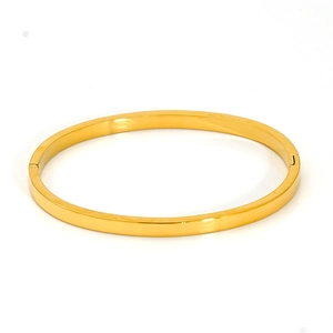 Close-up of polished 18K gold plated oval open bangle with reflective surface