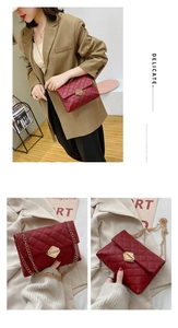 Detail of red quilted crossbody bag with gold chain strap and metal lock closure