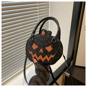 Detail of Halloween pumpkin bag featuring orange face embroidery and spider web stitching