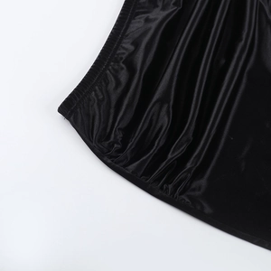 Dettaglio del tessuto in raso nero con arricciatura elastica e cuciture di precisione