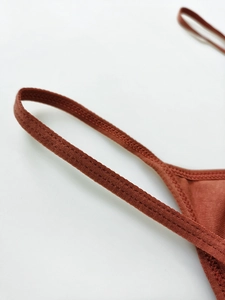 Detailed close-up of stitching on reddish-brown ribbed cotton sports bra straps