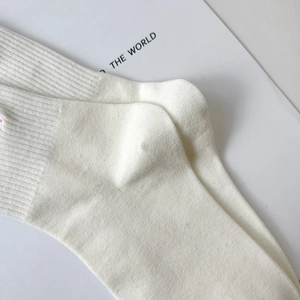 Close-up of cream white ribbed cotton socks featuring reinforced cuffs and soft texture