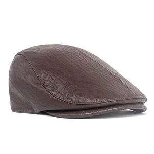 Detail of dark brown leather flat cap with visible texture and reinforced stitching