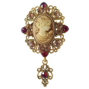 Spilla cammeo vintage con cornice dorata, strass colorati e un ciondolo a goccia mobile