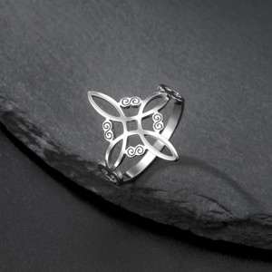 Silver stainless steel Celtic knot ring with intricate openwork patterns on slate