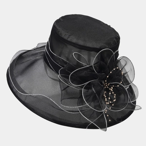 Détail du chapeau en organza noir avec fleur en tulle et perles jaunes nacrées