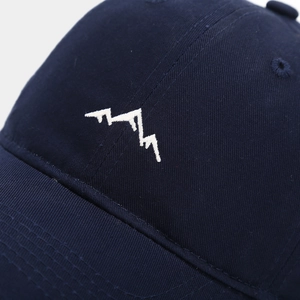 Close-up of white mountain embroidery on navy cotton twill outdoor baseball cap