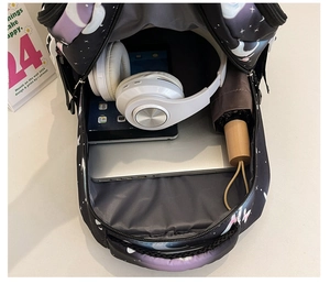 Internal view of astronaut print backpack showing spacious main compartment and pockets