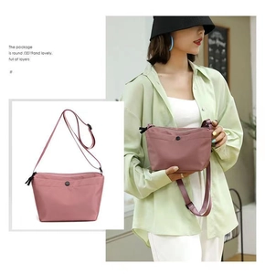 Detail of dusty pink lightweight crossbody bag with adjustable strap and front pocket