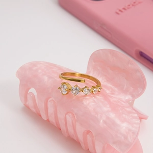 Detailed close-up of an adjustable gold stainless steel ring with five sparkling zircons