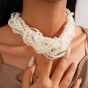Close-up of multilayered faux pearl necklace with twisted strands and rhinestone accents