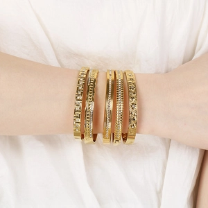 Close-up of five 18K gold plated stainless steel bangles with diamonds on silk