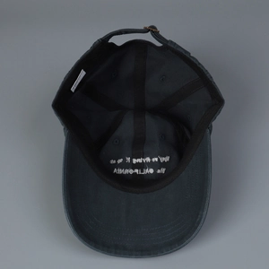 Interior view of grey cotton baseball cap showing embroidery, sweatband, and metal buckle