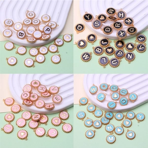 Detail showing 26 colorful enamel alphabet charms in gold trim for DIY jewelry