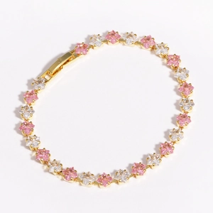 Elegant gold bracelet with sparkling pink and white square zircons on white background