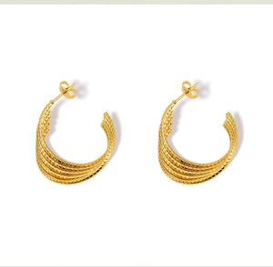 Detail of 18k gold plated U-shaped earrings with textured woven pattern and polished finish