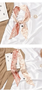 Detail of elegant Toile de Jouy silk scarf tied in a bow with vintage letter A print