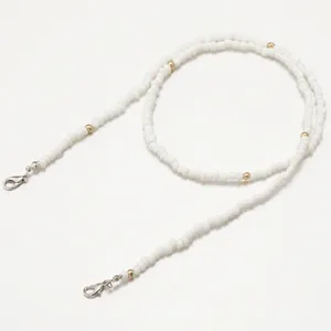 Detail of white beaded chain with gold accents and silver lobster clasps for eyewear
