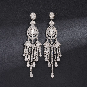 Detailed macro view of long silver tassel earrings with sparkling rhinestone crystals