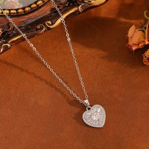 Détail du collier coeur en argent avec zircons brillants sur fond vintage chic