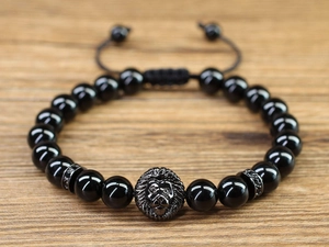 Macro detail of lion head charm on 8mm black beaded bracelet with adjustable cord