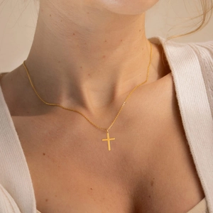 Close-up of minimalist 18K gold stainless steel cross pendant necklace on neck