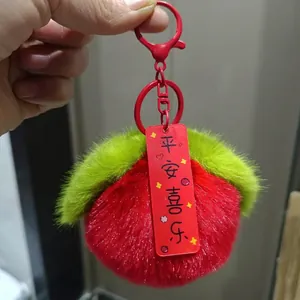 Dettaglio portachiavi in peluche rosso con ciondolo portafortuna e chiusura in metallo