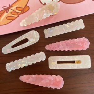 Elegant geometric acetate hair clips set in pearl white and pink with gold metal base